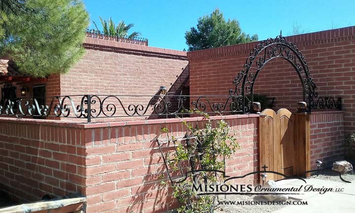decorative metal wall fencing on top of brick wall with arched entry